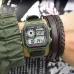 Wrist view of Casio AE-1200WHB-3BVDF Digital Watch with green casing beside leather bracelet and fabric sleeve.