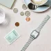 Tabletop view of Casio AQ-230A-7DMQ Watch beside coffee cup, coins, and sugar packet in casual café setting.