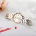 Close-up of Casio LTP-1183G-7ADF Watch with gold bezel and white dial placed on soft fabric beside pink flowers.