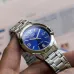 Handheld view of Casio MTP-1215A-2ADF Analog Watch with silver band and luminous-coated hands on blue dial.