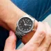 Wrist view of Casio MTP-V005D-1B4UDF Analog Watch with silver band and black dial worn against denim clothing.