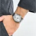 Wrist view of Casio MTP-V005D-7B4UDF Analog Watch with silver band and white dial worn under dark sleeve.