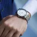 Wrist view of Casio MTP-V005D-7BUDF Analog Watch with silver band and white dial worn with suit and shirt cuff.