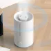 White minimalist humidifier with top mist outlet on wooden floor, showing wide mist diffusion and front water level indicator