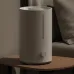 Compact white humidifier on bedside table, soft lighting, visible mist outlet, front knob control and vertical water level window