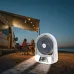 Outdoor camping view of EP-608 Solar Fan placed near camper van under awning with string lights.