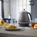 Delonghi KBOT2001.GY 1.7L Icona Metallics Electric Kettle placed outdoors on table with rustic background