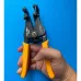 Handheld view of Tolsen 38049 Automatic Wire Stripper with yellow handles and spring mechanism against blue background.