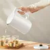 Xiaomi Electric Kettle 2 Lite pouring hot water into glass cups from a side-angle view.