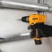 Side action view of the INGCO CDLI12206 Cordless Drill drilling into a wall for installation near metal pipes.