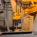 Work view of INGCO ID7118 Drill Machine boring into metal surface with sparks flying and protective gloves worn.