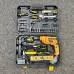 Portable Tolsen 79685 Hammer Drill toolkit open on asphalt showing drill, bits, tape, knife, and spirit level.