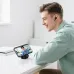 Lifestyle view of Hoco EQ100 AI translation earbuds connected to a smartphone during real-time translation use.