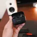 Handheld view of Kieslect Adjustable Earbuds showing compact charging case held in hand with earbuds inside