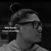A man wearing the black Zeblaze AI Shooting Glasses in a black and white shot, with a text overlay for real-time translation.