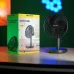 Front view of Awei F30 Mini Desk Fan beside HAVIT packaging box showing compact black design on flat surface.