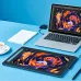 Digital drawing tablet connected to laptop on blue desk, displaying colorful artwork with stylus and workspace setup.