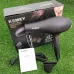 Product view of Kemei KM-5805 Hair Dryer on grass with packaging box and instruction manual included.