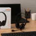 Desk setup view of the Meetion MT‑HP003U Wired Headphone placed beside keyboard and accessories on a wooden workspace.