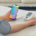 Close‑up of a hand holding Omron HEM‑7142T2 BP Monitor with attached cuff and visible START/STOP button.