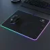 Angled desk view of the Meetion MT‑P010 RGB Anti Slip Gaming Mouse Pad showing glowing LED edges with mouse placed on textured surface