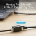 Ethernet cable extender connecting two LAN cables to increase length placed on desk near laptop with text overlay