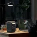 Indoor desk view of Anker SOLIX C300 Portable Power Station powering laptop beside books and lamp.
