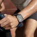 Close-up of Amazfit Bip Max on wrist gripping exercise bike handle displaying real-time fitness metrics.