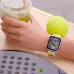 Top-down view of a HUAWEI WATCH FIT 5 on a wrist near a tennis ball and a refreshing green drink.