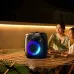 Awei KA22 Portable Bluetooth Speaker glows with blue light on a table in an outdoor evening setting.