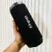 Side view of Unikyy S18 Portable Bluetooth Speaker held in hand highlighting fabric texture and vertical logo branding design