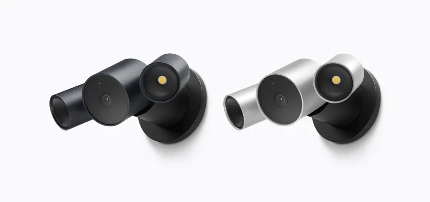 Front-angled view of two LG Floodlight Cam, outdoor spotlight security cameras presented side-by-side in dark gray and silver finishes.